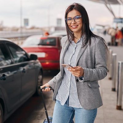 happy-caucasian-woman-traveller-airport-terminal-is-taking-taxi